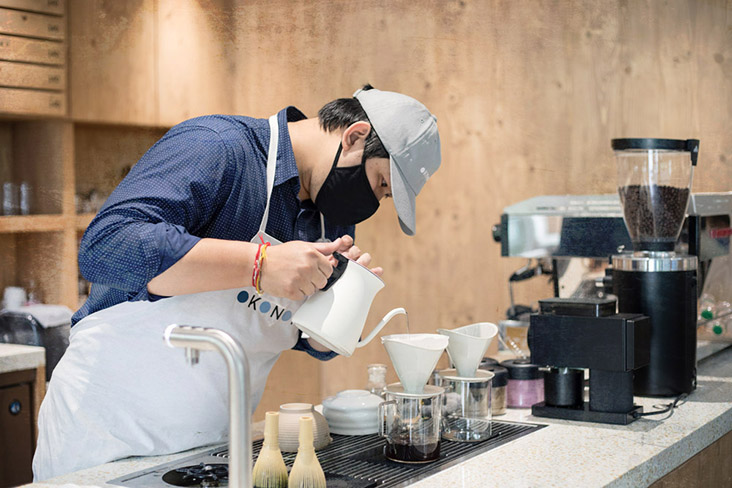 Barista brewing pour over coffee at the slow bar.