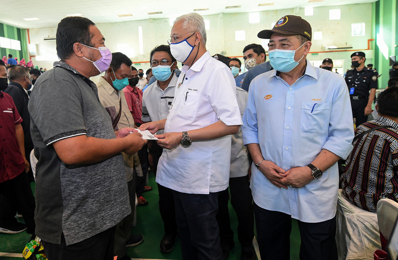 Prime Minister Datuk Seri Ismail Sabri Yaakob (centre) presenting assistance to flood victim Abdul Rahman Kili in Pitas District, Sabah, January 8, 2022. u00e2u20acu201d Bernama pic