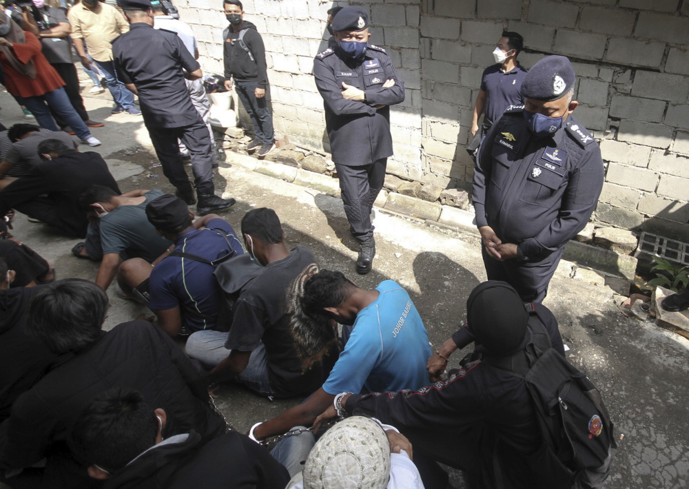 Johor police chief Datuk Kamarul Zaman Mamat (right) with his deputy Datuk Khaw Kok Chin (centre) and the arrested individuals in Kampung Melayu Pandan in Johor Baru, January 21, 2022. u00e2u20acu201d Bernama pic 