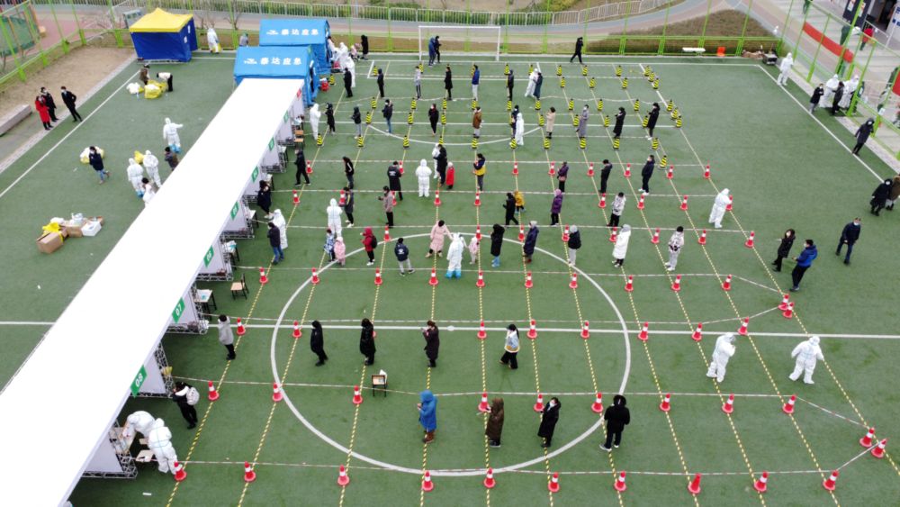 An aerial view shows people lining up at a nucleic acid testing site during the second round of mass testing for Covid-19, after local cases of the Omicron variant were detected in Tianjin, China January 12, 2022. u00e2u20acu201d China Daily via Reuters