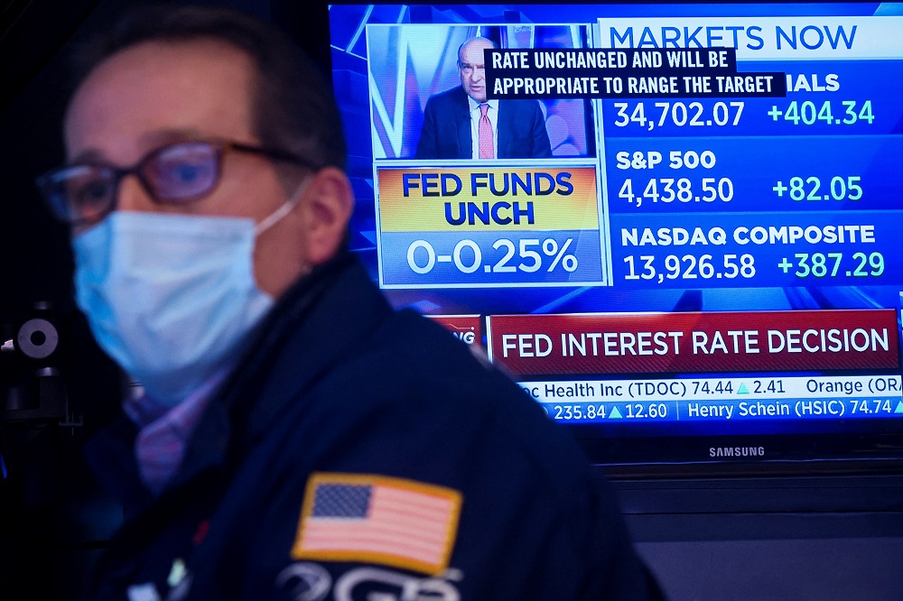 A screen displays the Fed rate announcement as a specialist trader works at his post on the floor of the New York Stock Exchange (NYSE) in New York January 26, 2022. u00e2u20acu2022 Reuters pic