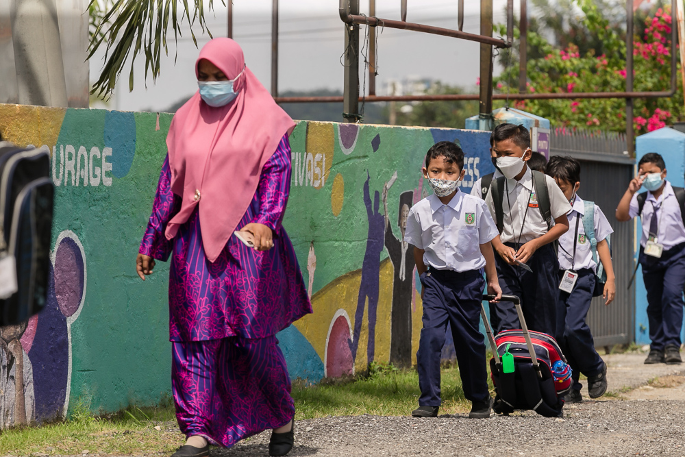 A teacher leads students towards Sekolah Kebangsaan Semenyih, as schools reopened in Selangor, January 10, 2022. u00e2u20acu201d Picture by Devan Manuel