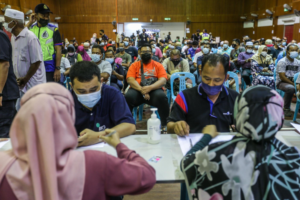 Flood victims queuing up to fill in the application form for Bantuan Wang Ihsan (BWI) and Bantuan Selangor Bangkit (BSB) at Dewan Kenanga Section 28 in Shah Alam, January 11, 2022.  u00e2u20acu201d Picture by Hari Anggara 