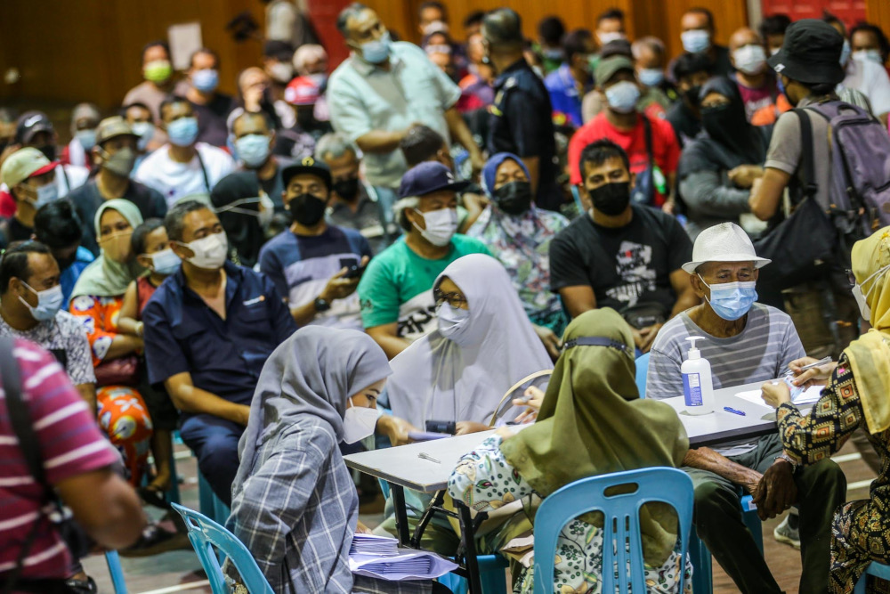 Flood victims queuing up to fill in the application form for Bantuan Wang Ihsan (BWI) and Bantuan Selangor Bangkit (BSB) at Dewan Kenanga Section 28 in Shah Alam, January 11, 2022.  u00e2u20acu201d Picture by Hari Anggara 