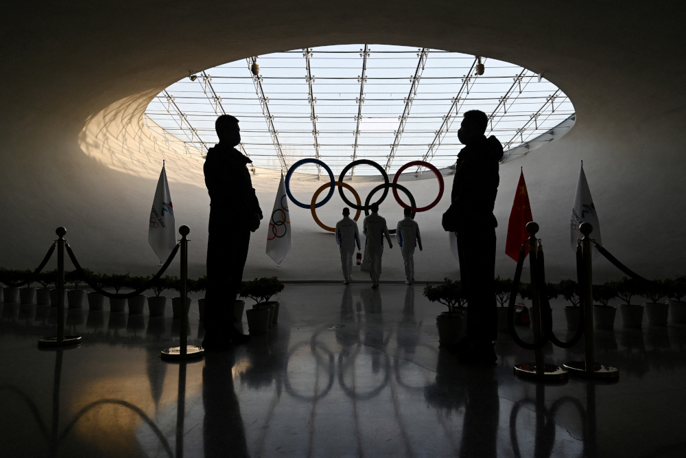 Security guards stand by as workers refuel the Olympic flame in the Olympic Tower in Beijing January 3, 2022, a month before the opening of the 2022 Winter Olympic Games on February 4, 2022. u00e2u20acu201d AFP pic