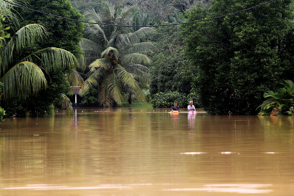 Two Taman Pinggiran Sungai Kelamah residents are seen wading in the flood in Tampin January 1, 2022. u00e2u20acu201d Bernama pic