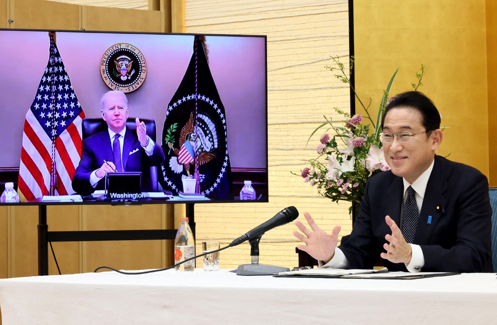 This handout picture taken and released by the Japan's Cabinet Public Relations Office via Jiji Press shows Japan's Prime Minister Fumio Kishida (right) meeting with US President Joe Biden during a virtual summit from prime minister's office in Tokyo on J