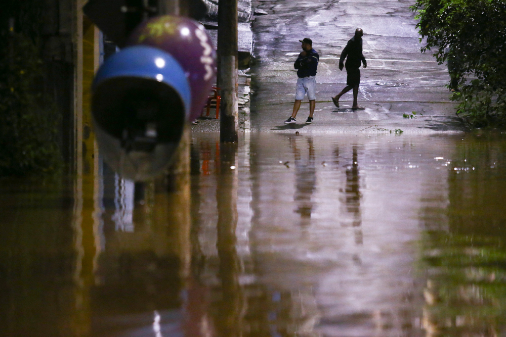 People stand in a flooded street after heavy rain in Caieiras, Brazil January 30, 2022. u00e2u20acu201d Reuters picnn