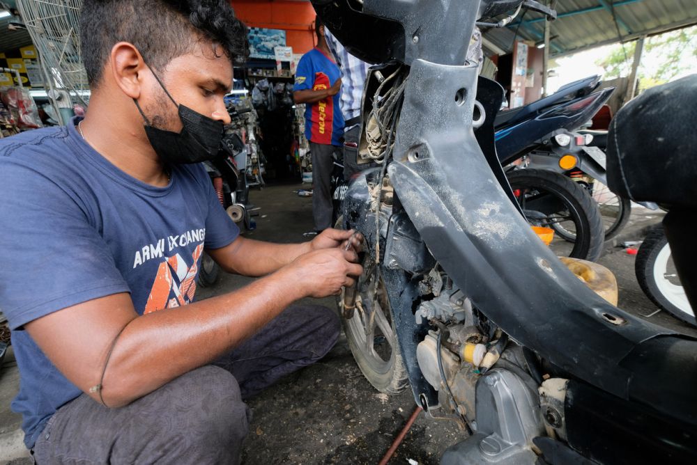 Rajendran is seen working on a motorbike in his workshop in Dengkil January 4, 2022. u00e2u20acu201d Bernama pic