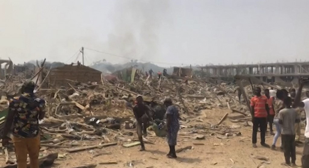 Handout video grab obtained on January 20, 2022 shows people gathering at destroyed buildings after a blast caused by the crash between a truck carrying explosives and a motorcycle in Apiate, near the city of Bogoso, Ghana. u00e2u20acu201d ConnectFM/TV3 / AFP pic