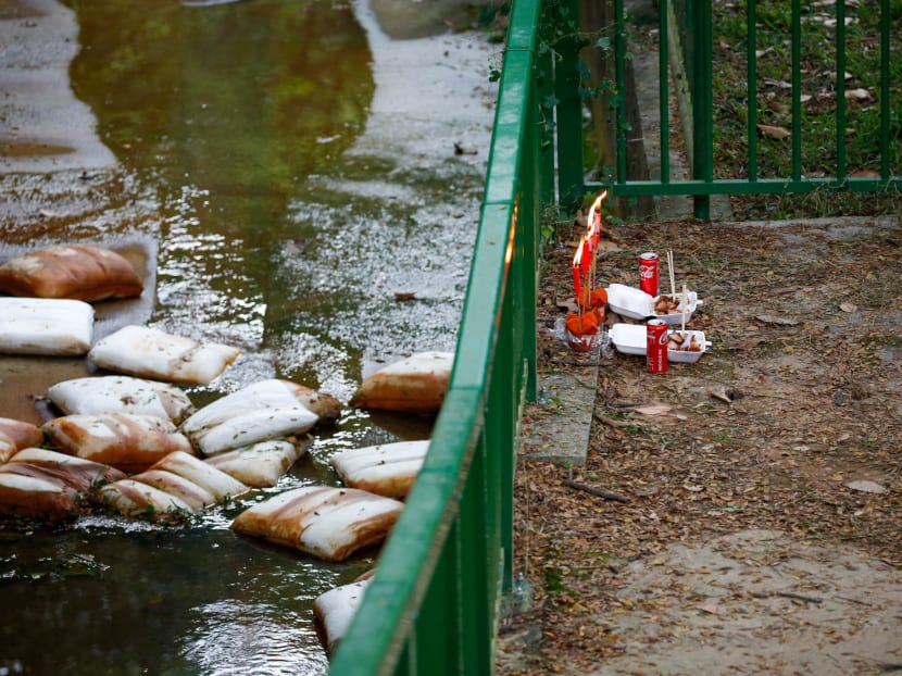 Offerings left near a drain at a playground along Greenridge Crescent in Upper Bukit Timah, where two 11-year-old boys were found dead. u00e2u20acu201d TODAY pic