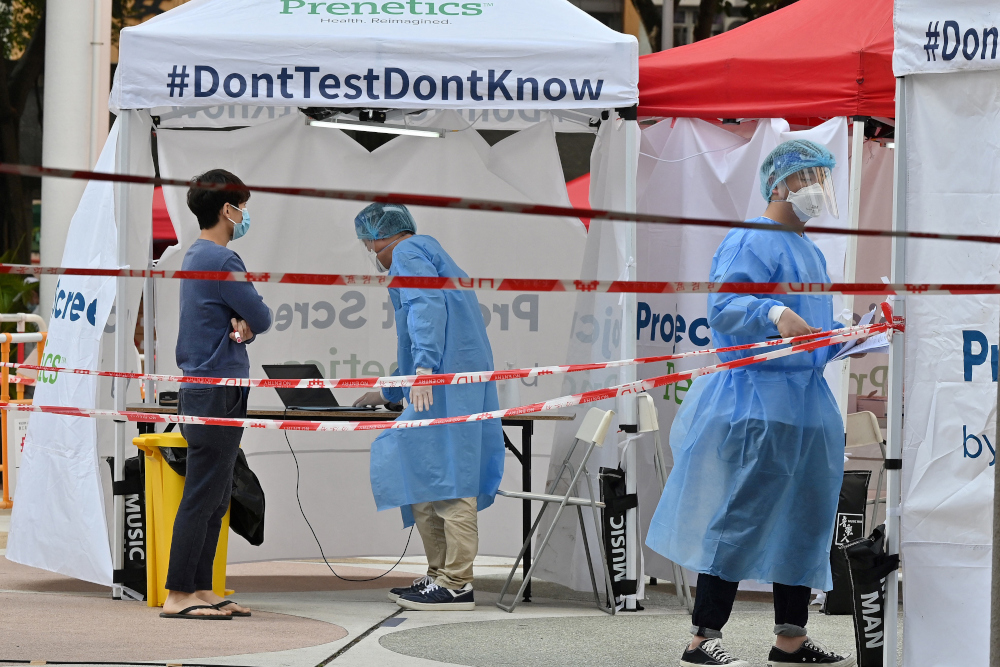 Officials in protective closing work at a Covid-19 testing station following a recent cluster of coronavirus cases, at the Kwai Chung housing estate in Hong Kong, January 27, 2022. u00e2u20acu201d AFP pic 