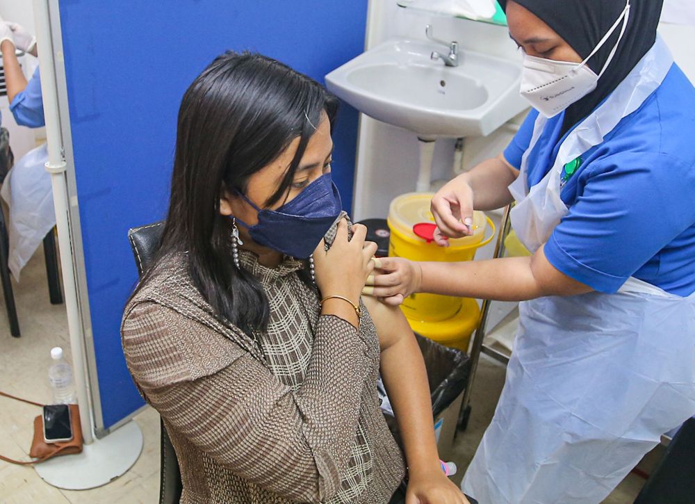 A woman receives her Covid-19 booster shot at the Perak Community Specialist Hospital in Ipoh January 3, 2022. u00e2u20acu201d Picture by Farhan Najibnn