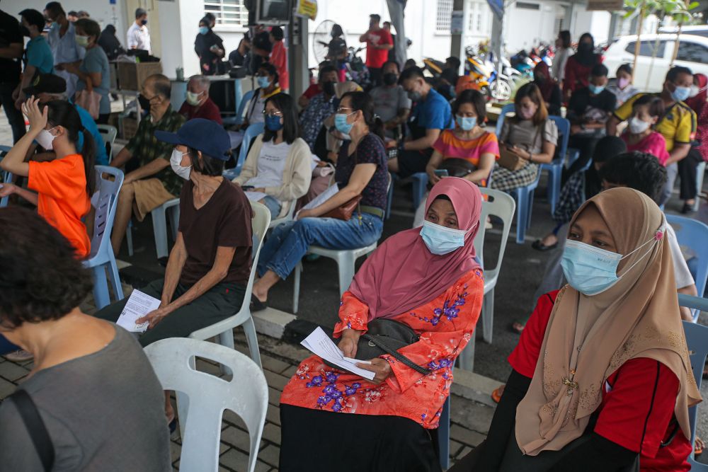 People wait to receive their Covid-19 booster shot at the Perak Community Specialist Hospital in Ipoh January 3, 2022. u00e2u20acu201d Picture by Farhan Najib