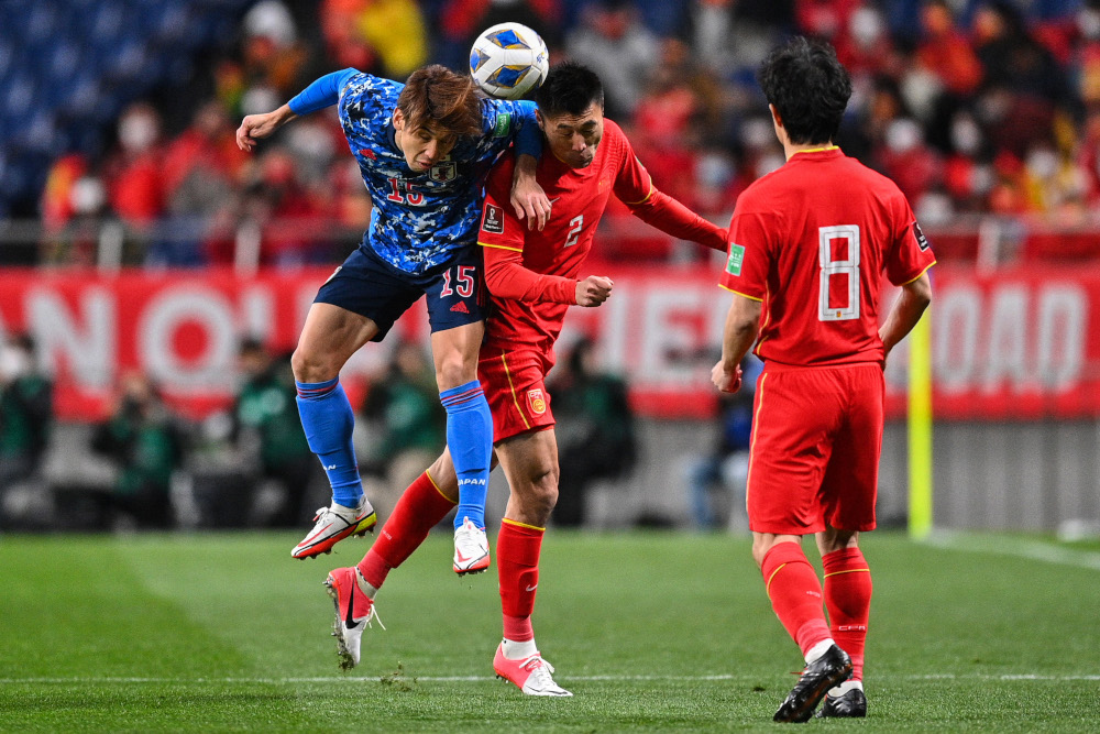 Japanu00e2u20acu2122s Yuya Osako (left) and Chinau00e2u20acu2122s Zheng Zheng (centre) compete for the ball during the Fifa World Cup Qatar 2022 Asian zone qualification match at Saitama Stadium in Saitama, January 27, 2022. u00e2u20acu201d AFP pic 