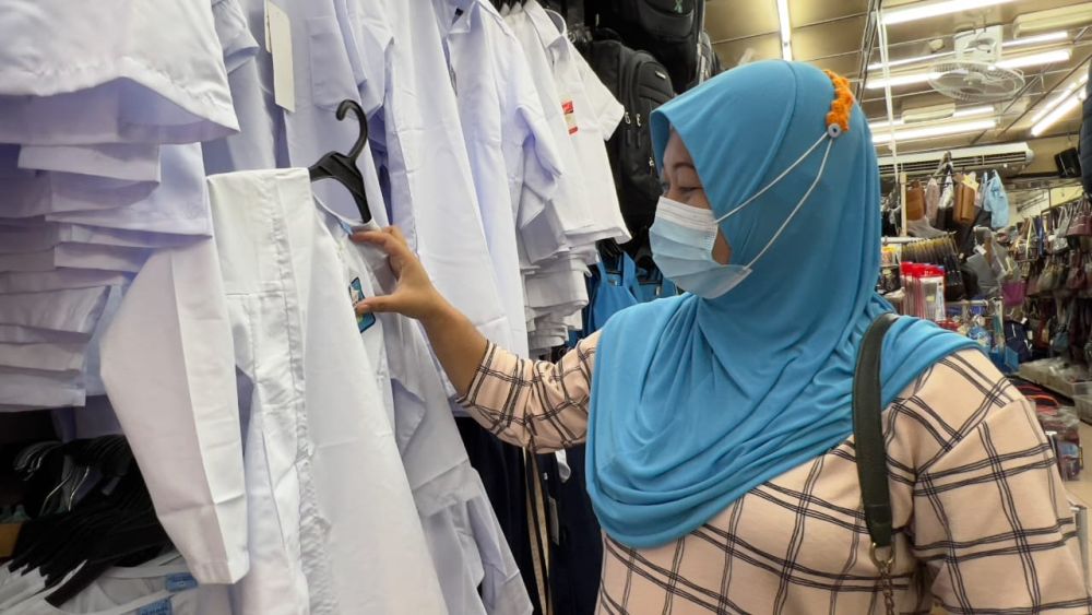 Noraini browses through some u00e2u20acu02dcbaju kurungu00e2u20acu2122 uniforms at a shop in India Street Pedestrian Mall. u00e2u20acu201d Picture by Roystein Emmor/ Borneo Post