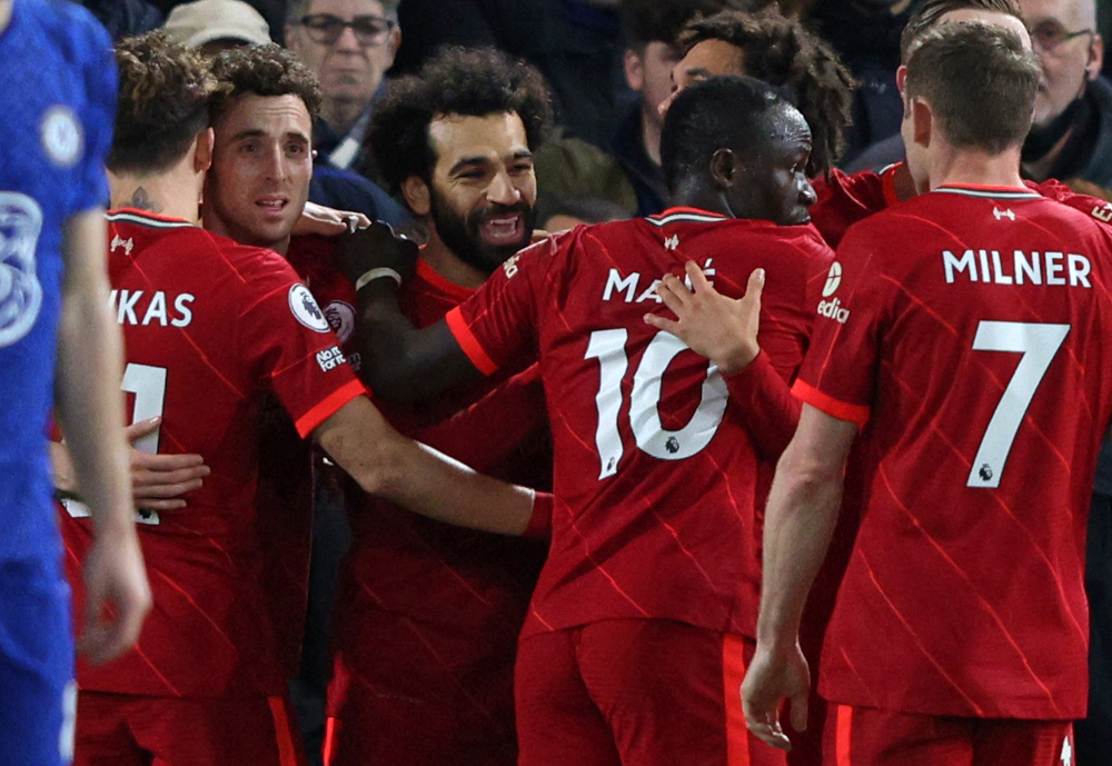 Liverpool midfielder Mohamed Salah is mobbed by teammates after scoring the teamu00e2u20acu2122s second goal during the English Premier League football match between Chelsea and Liverpool at Stamford Bridge in London, January 2, 2022. u00e2u20acu201d AFP picnn
