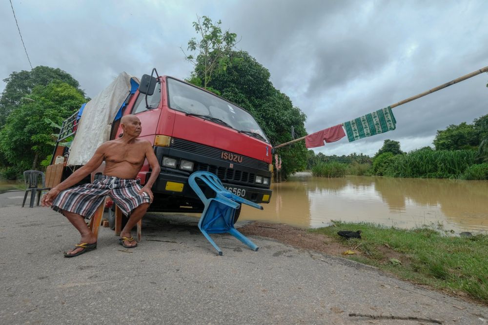 A man looks at as water levels continue to rise in Kampung Belimbing Dalam, near Durian Tunggal, Alor Gajah January 3, 2022. u00e2u20acu201d Bernama picnn