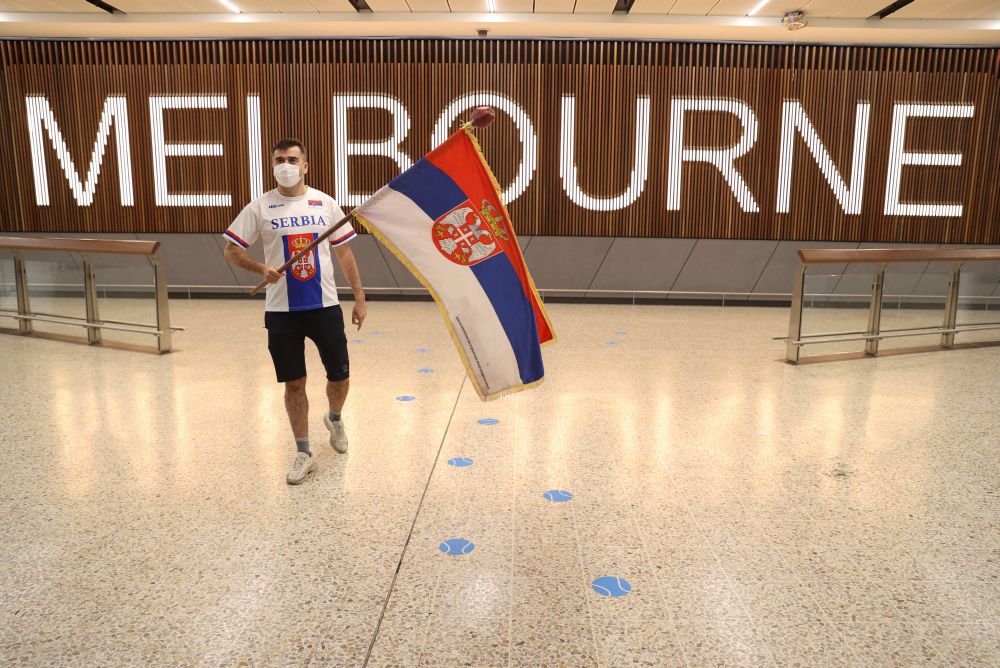 Serbian fan Slobodan Bendjo carries his nation's flag while waiting for Novak Djokovic to arrive for the Australian Open tennis tournament at the Melbourne Airport January 6, 2022. u00e2u20acu201d Reuters pic