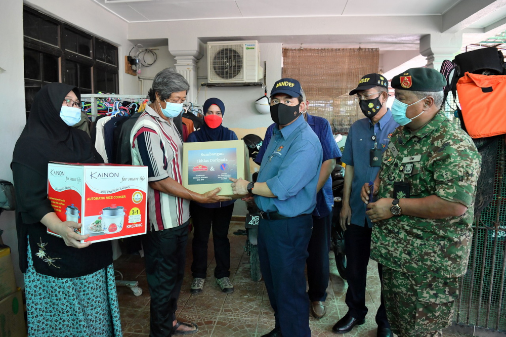 Deputy Defence Minister Datuk Seri Ikmal Hisham Abdul Aziz hands out aid to MAF veteran Nordin Mohammad who was affected by the recent floods in Taman Sri Nanding, Hulu Langat, January 4, 2022. u00e2u20acu201d Bernama picn