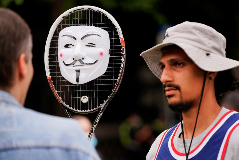 A supporter of Serbian tennis player Novak Djokovic holds a decorated tennis racket outside the Park Hotel, where the star athlete is believed to be held in Melbourne January 7, 2022. u00e2u20acu201d Reuters pic