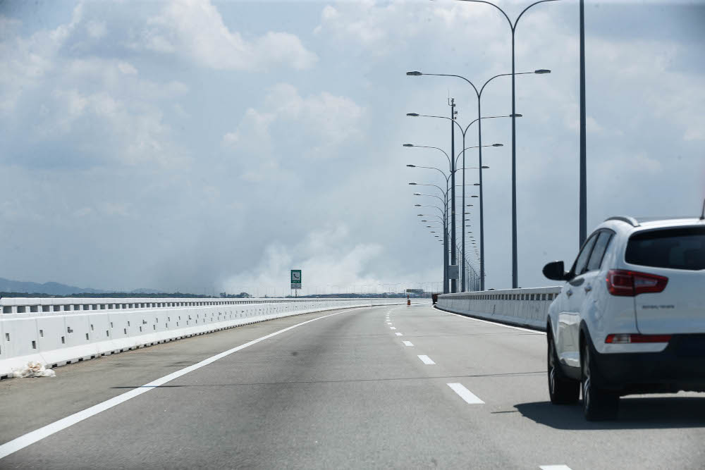 Thick smoke visible from Sultan Abdul Halim Muadzam Shah Bridge as the fire on the Pulau Burung landfill in Penang continues, January 17, 2022. u00e2u20acu201d Picture by Sayuti Zainudin