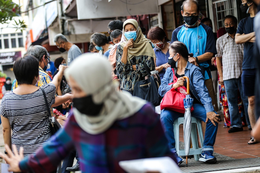 People line up, especially senior citizens, to get their Covid-19 booster dose at a vaccination centre in Vision College, Kelana Jaya, January 4, 2022. u00e2u20acu201d Picture by Hari Anggara