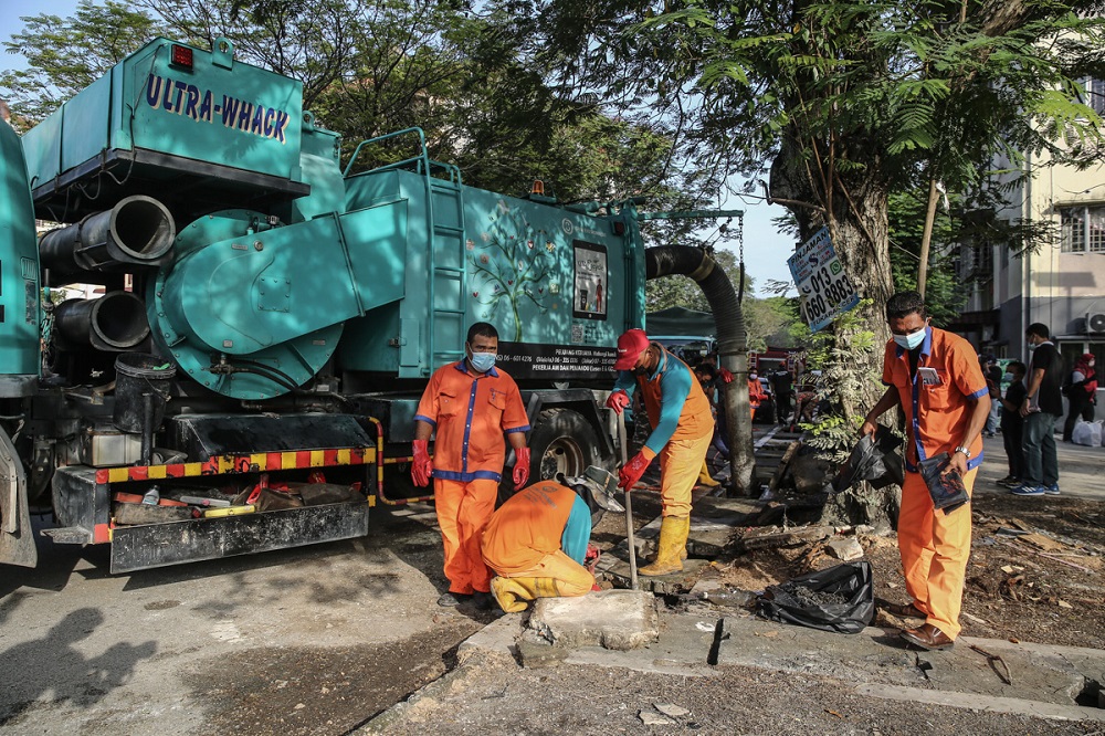 Workers are seen doing some clean-up during the Post Flood Mega Cleaning Programme at Taman Sri Muda in Shah Alam January 8, 2022. u00e2u20acu2022 Picture by Yusof Mat Isa