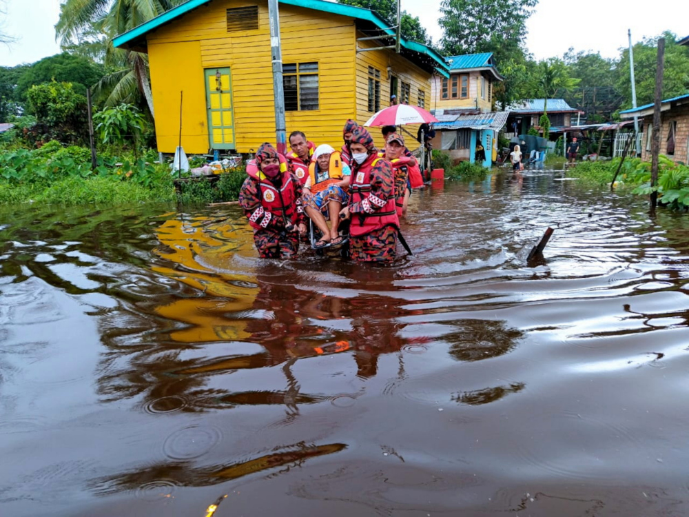 Sungai Merah Fire and Rescue Dept personnel rescue a resident of Kampung Seduan Jaya in Sibu from the flood, January 12, 2022. u00e2u20acu201d Bernama picnn