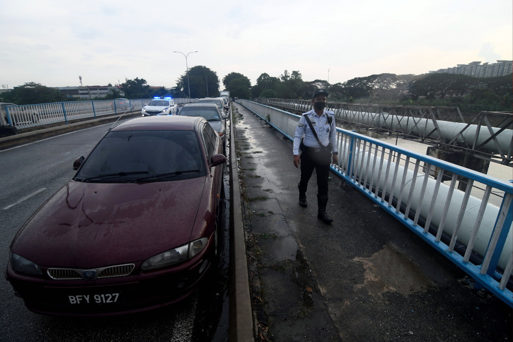 A traffic policeman patrols the area around Jalan Budiman in Taman Sri Muda, Section 25 Shah Alam in preparation for heavy rain, January 24, 2022. u00e2u20acu201d Bernama pic 