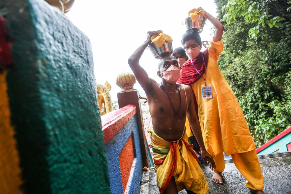Hindu devotees carry offerings on their heads as they climb the steps to the Sri Subramaniam Temple in Batu Caves during Thaipusam January 18, 2022. — Picture by Hari Anggara