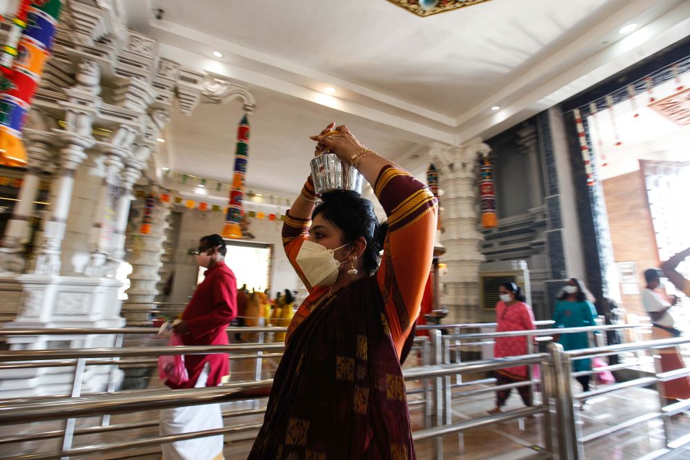 Devotees carry offerings on their heads as they make their way to the Hilltop Murugan Temple in George Town during Thaipusam January 18, 2022. — Picture by Sayuti Zainudin