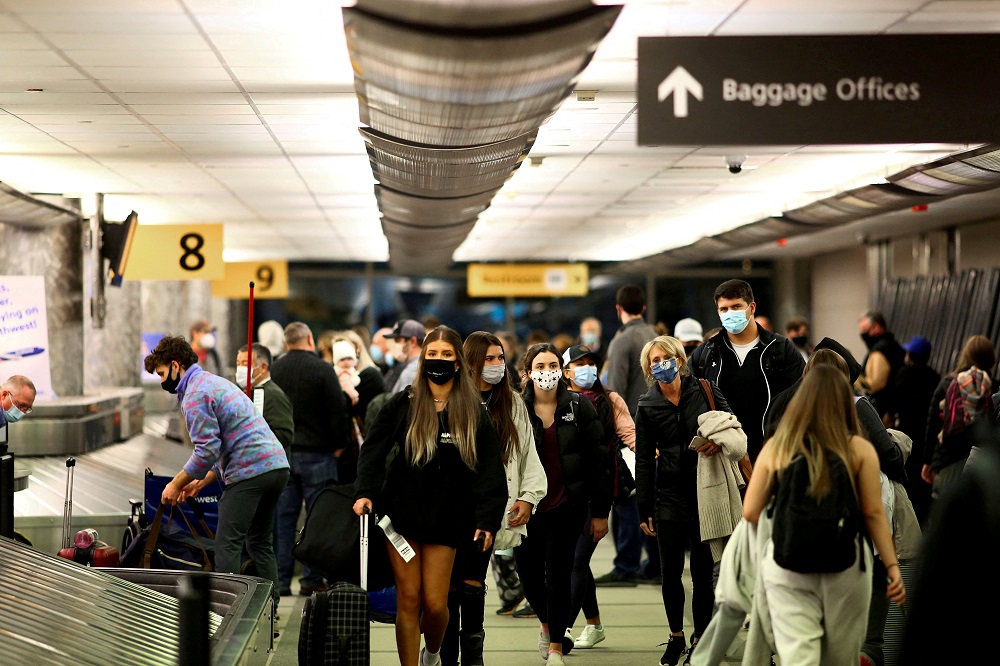 Travellers wearing protective face masks to prevent the spread of the coronavirus disease, reclaim their luggage at the airport in Denver, Colorado November 24, 2020. u00e2u20acu2022 Reuters file pic