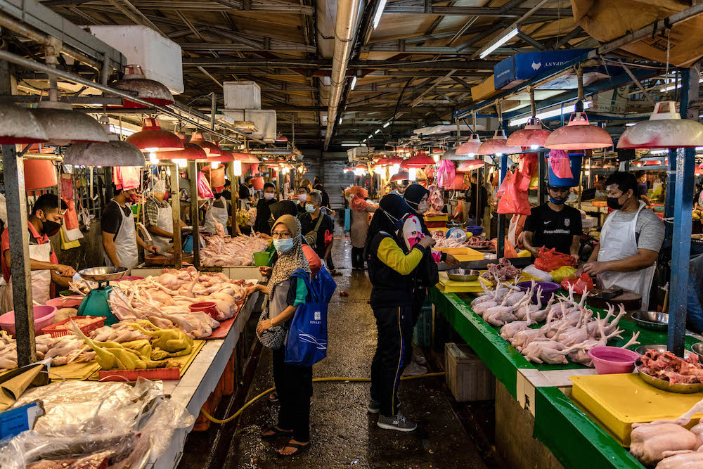Customers buy chickens at a market in Chow Kit, Kuala Lumpur February 3, 2022. u00e2u20acu201d Picture by Firdaus Latif