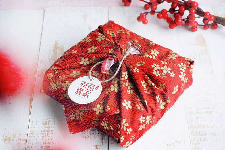 Wrapping gift sets in decorative cloth for aesthetic appeal.