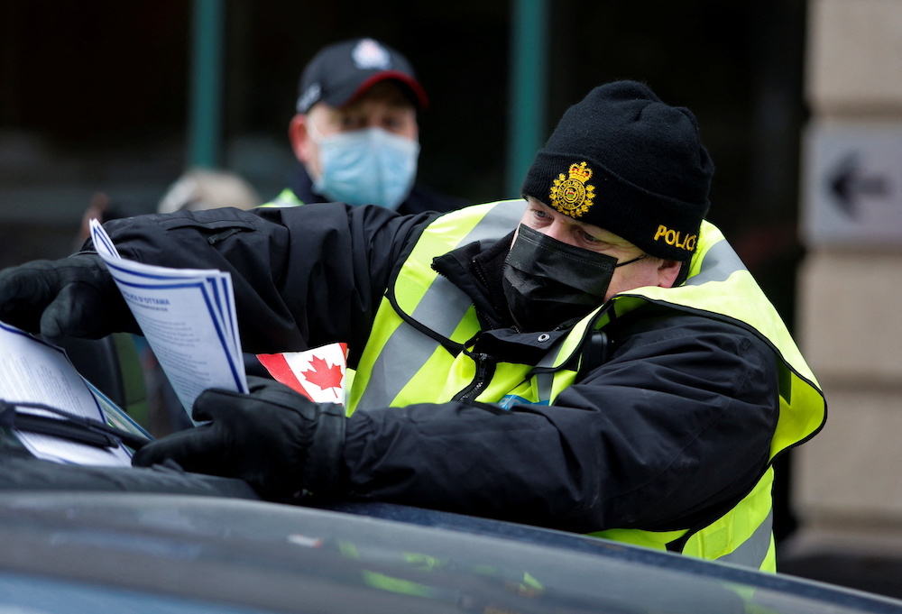 A police officer places a u00e2u20acu02dcNotice to Demonstration Participants,u00e2u20acu2122 telling demonstrators to leave the area, on a vehicle as truckers and their supporters continue to protest against Covid-19 vaccine mandates in Ottawa, Ontario, Canada February 16, 2022
