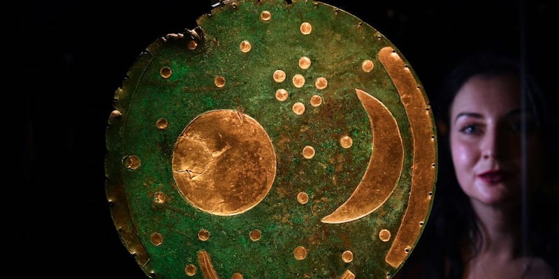 A museum employee looks at the oldest known sky-map made of gold and bronze dated of 1600 BC and found in Nebra, Saxony-Anhalt, Germany, at the new exhibition u00e2u20acu02dcThe World of Stonehengeu00e2u20acu2122 at the British Museum. u00e2u20acu201d AFP pic