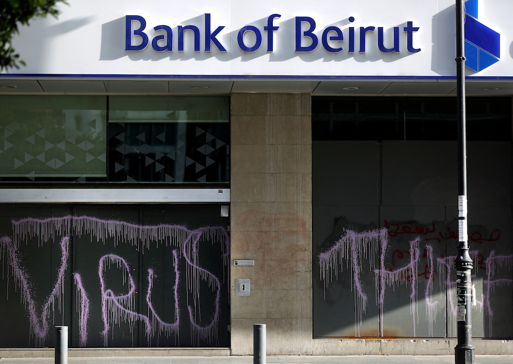 In this file photo taken on May 18, 2020 Graffiti reading u00e2u20acu02dcVIRUSu00e2u20acu2122 and u00e2u20acu02dcTHIEFu00e2u20acu2122 covers the facade of a fortified local branch of the Bank of Beirut in the Lebanese capital. u00e2u20acu201d AFP pic