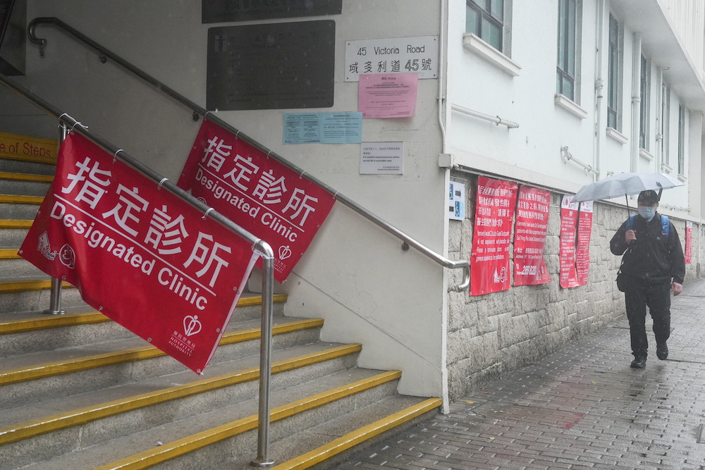 A man holding an umbrella and wearing a face mask walks outside a clinic designated to treat patients for Covid-19, in Hong Kong, China February 19, 2022. u00e2u20acu201d Reuters pic