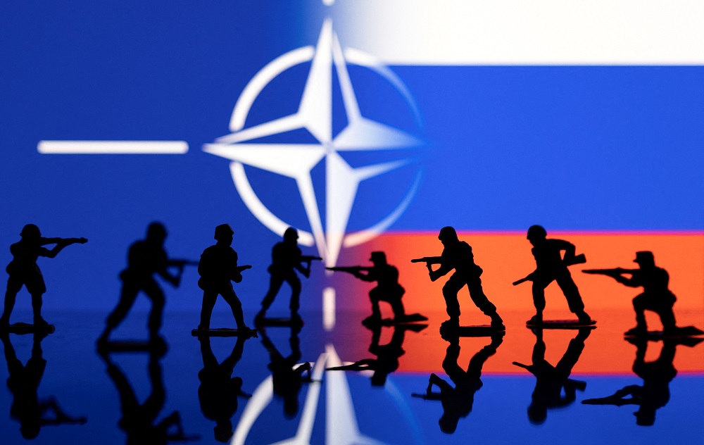 Army soldier figurines are displayed in front of the Nato logo and Russian flag colours background in this illustration taken February 13, 2022. u00e2u20acu201d Reuters pic