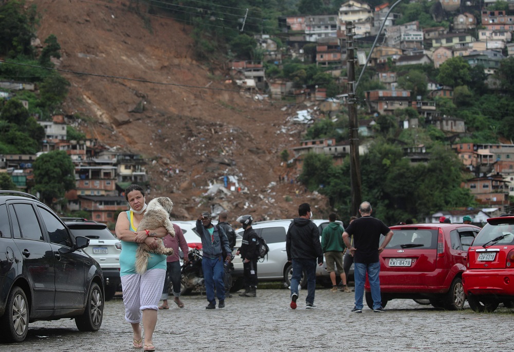 Viviane de Souza, 42, carries her dog at a shelter for displaced people after a mudslide at Morro da Oficina, following heavy rainfall in Petropolis, Brazil February 18, 2022. — Reuters pic
