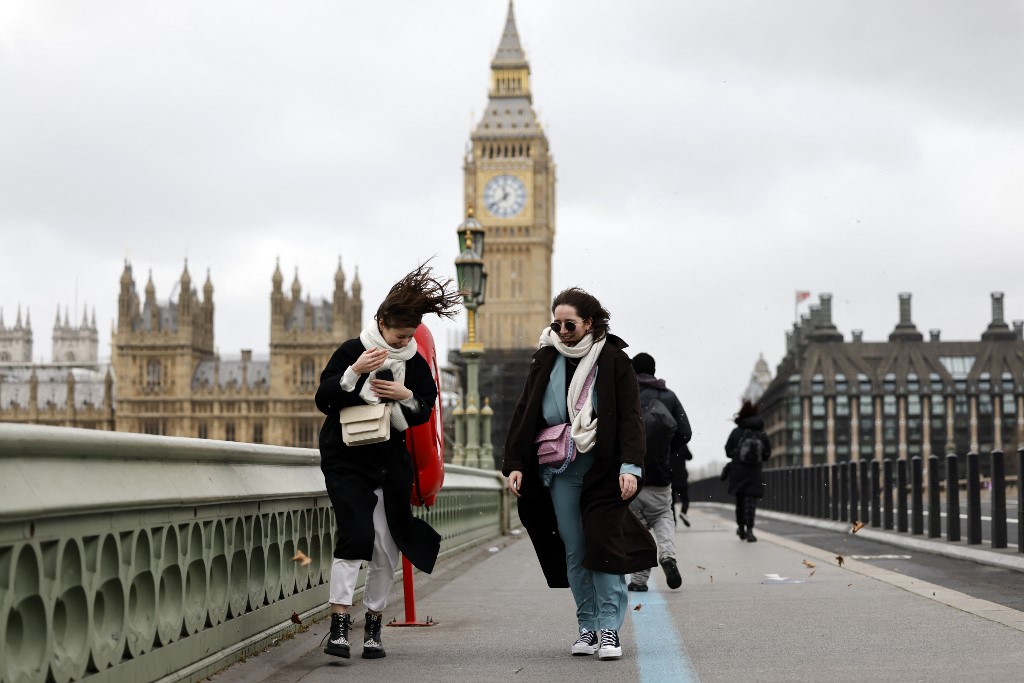 People struggle in the wind as they walk across Westminster Bridge, near the Houses of Parliament in central London February 18, 2022, as Storm Eunice brings high winds across the country. u00e2u20acu201d AFP pic