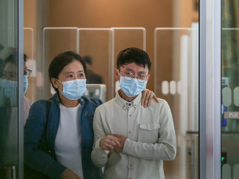 Nicholas Kwang Zhen Xing (right) leaving the State Courts on Feb 9, 2022. u00e2u20acu201d TODAY pic