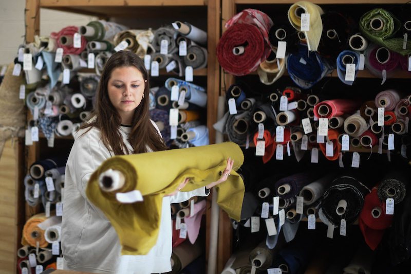 Molly picks up a roll of fabric at The New Craft House, a sewing workshop studio and designer deadstock fabric shop, works on online orders in Hackney, East London February 11, 2022. u00e2u20acu201d AFP pic