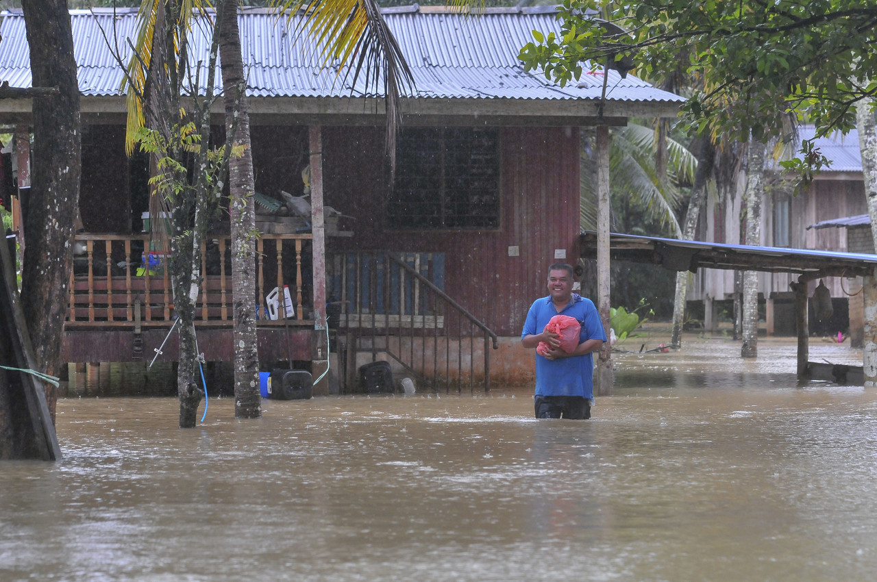 A resident wading through water in front of his house to move to a temporary evacuation centre (PPS) after his house was flooded due to continuous heavy rain during a survey in Kampung Kepah, Hulu Terengganu, February 26, 2022. u00e2u20acu201d Bernama pic
