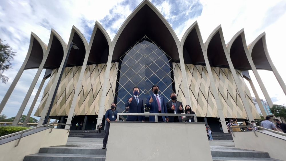 Abdul Karim, flanked by Hii (left) and Tazudin, pose in front of the Borneo Cultures Museum. u00e2u20acu201d Borneo Post pic