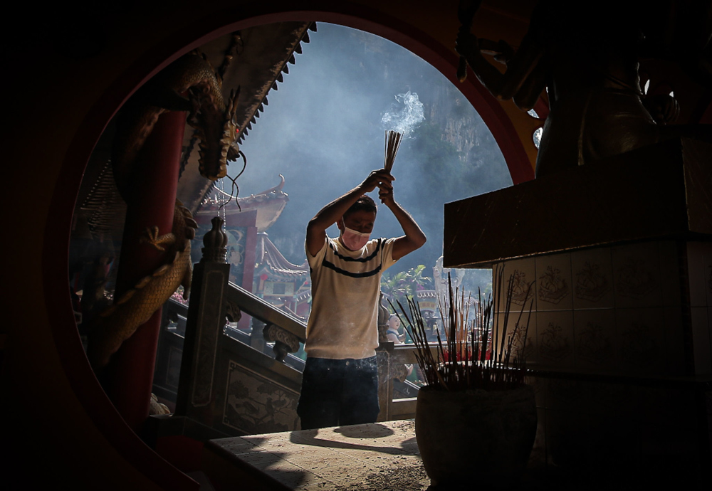 A man performs prayers during the Chinese New Year celebration at Ling Sen Tong Temple in Ipoh. — Picture by Farhan Najib
