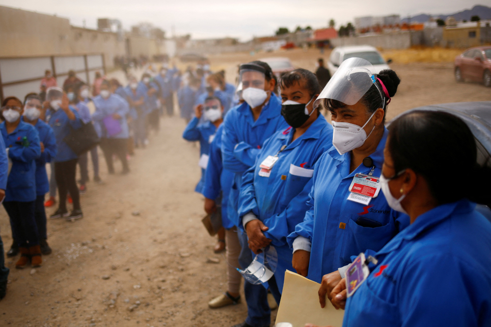 Employees of an assembly factory wait for a bus after receiving a booster shot of the AstraZeneca coronavirus disease (Covid-19) vaccine during a mass vaccination programme for people over 50 years, in Ciudad Juarez, Mexico February 1, 2022. u00e2u20acu201d Reuters p