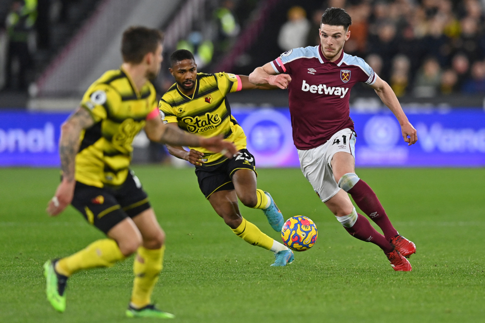 West Ham United midfielder Declan Rice runs with the ball as Watford striker Emmanuel Dennis closes in during the English Premier League match at the London Stadium, in London, February 8, 2022. u00e2u20acu2022 AFP picn