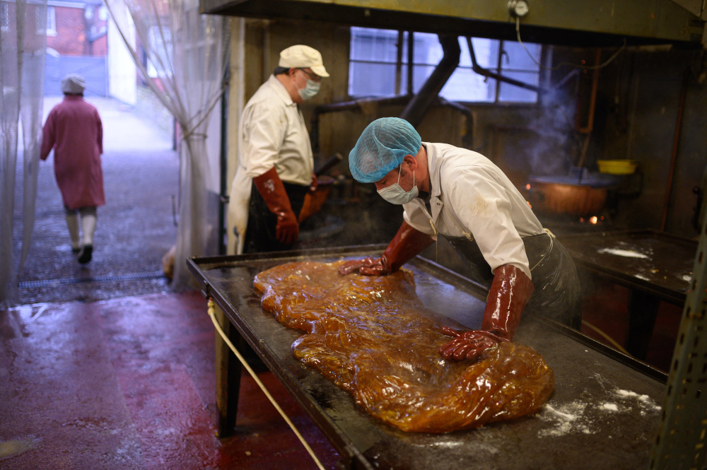Edward Gray sweet factory in central England evokes a bygone age where brass cauldrons steam with molten sugar and workers wrestle with huge chunks of gooey treacle, but its handmade produce now enjoys a global demand. — AFP pic